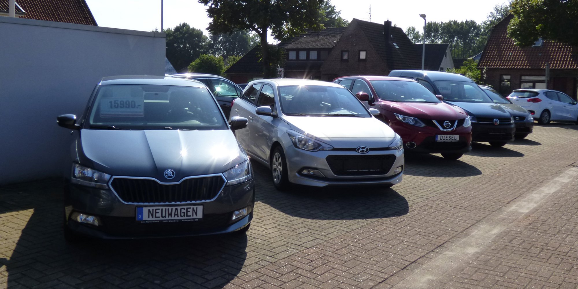 Reihe von Autos auf einem Parkplatz, vorne ein grauer Škoda.